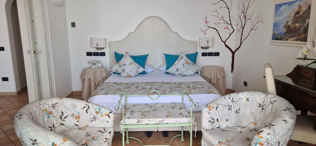 a bedroom with a bed and two chairs at Albergo La Conca Azzurra in Conca dei Marini