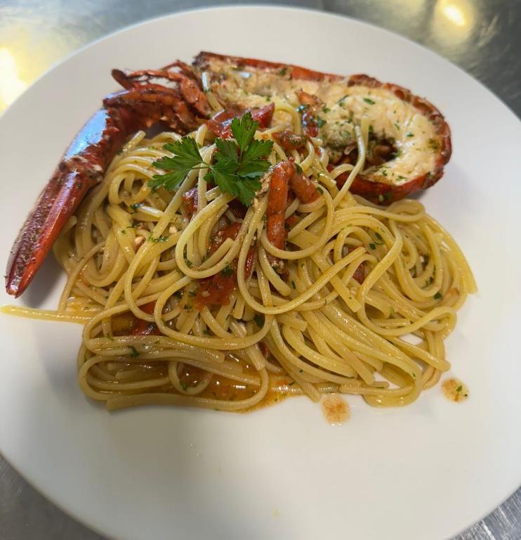 a white plate of pasta with meat and shrimp at Albergo La Conca Azzurra in Conca dei Marini
