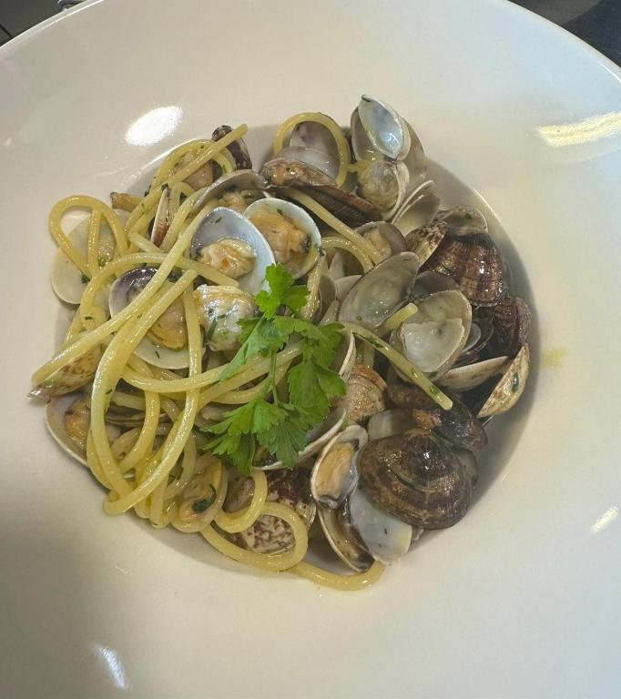a plate of pasta and oysters on a white plate at Albergo La Conca Azzurra in Conca dei Marini