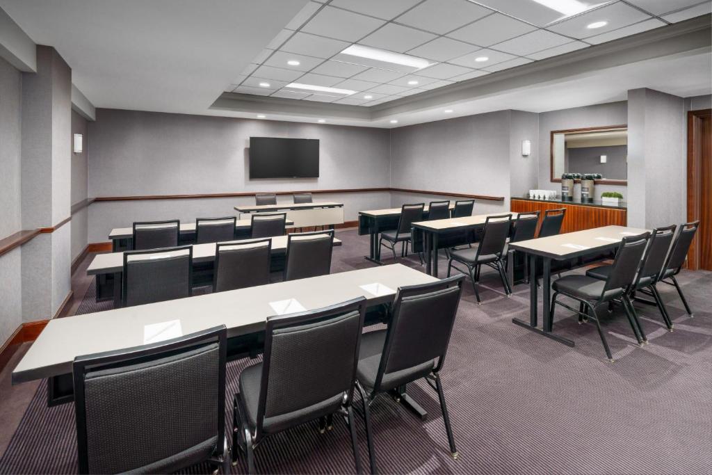 a conference room with tables and chairs and a screen at Residence Inn by Marriott New York Manhattan/Times Square in New York