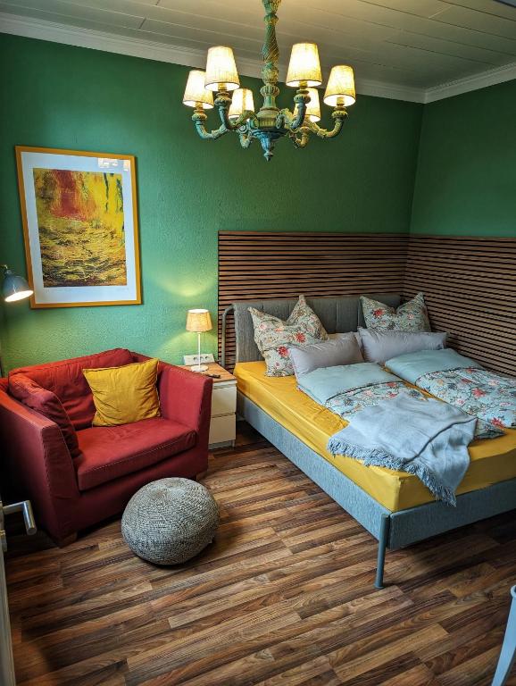 a bedroom with a bed and a red chair at Wilhelms Kojen - Backbordkoje in Wilhelmshaven