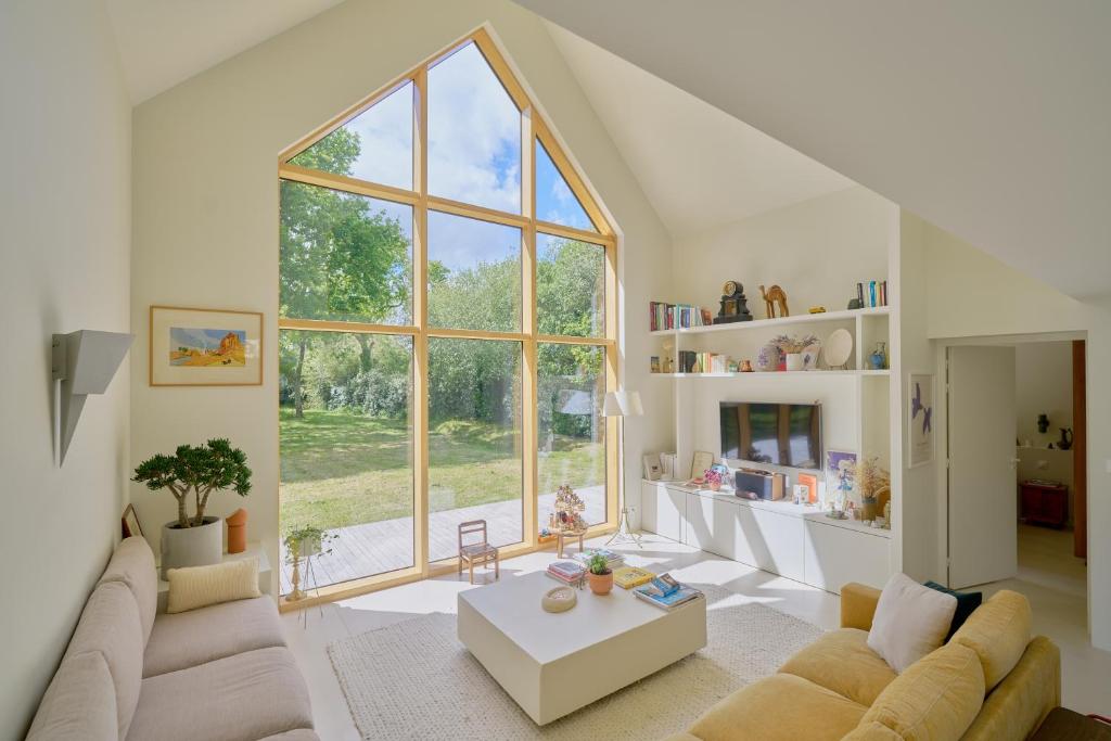 un grand salon avec une grande fenêtre dans l'établissement La Grande Josy, à Fouesnant
