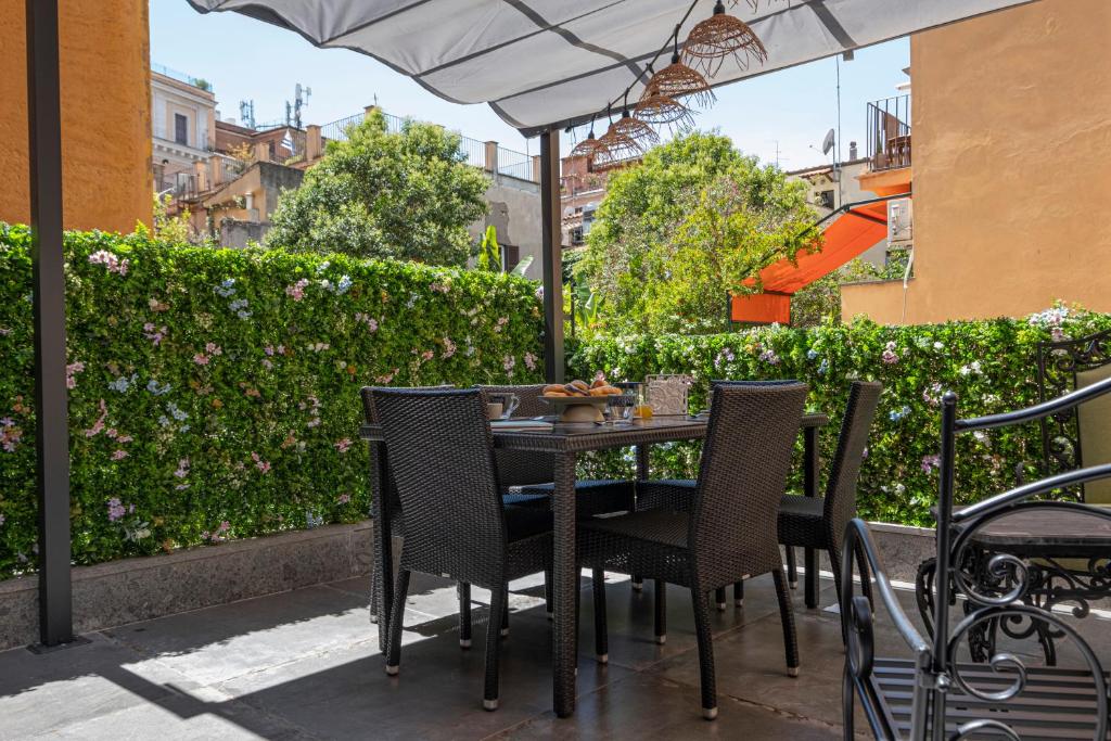 a table with chairs and an umbrella on a patio at Vatican Boutique Apartment with large Terrace in Rome