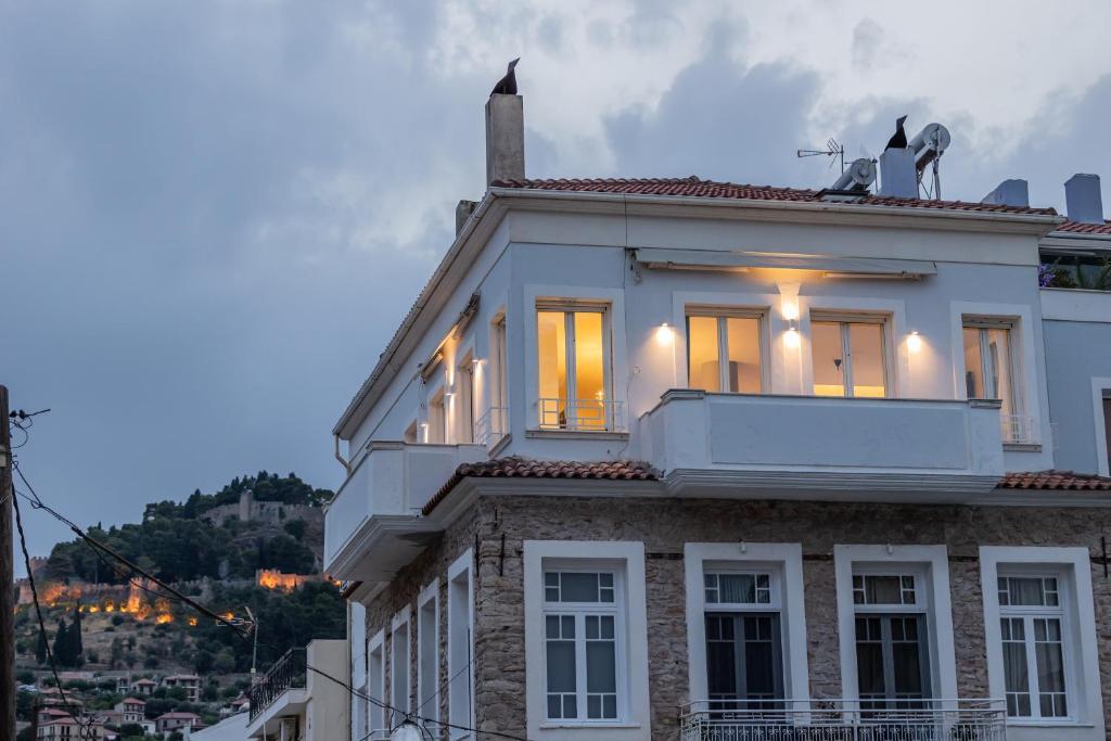 Una casa blanca con un balcón encima. en Lepanto Phos, en Nafpaktos