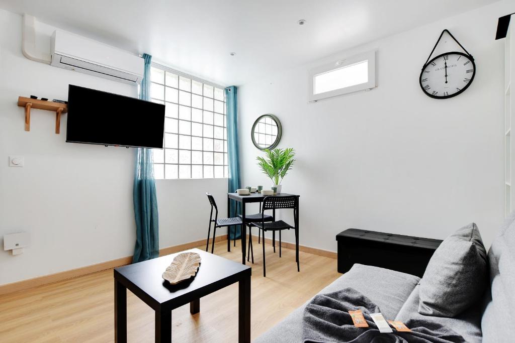 un salon avec un canapé et une table dans l'établissement Charming 1 Bedroom - Romainville 1, à Bagnolet
