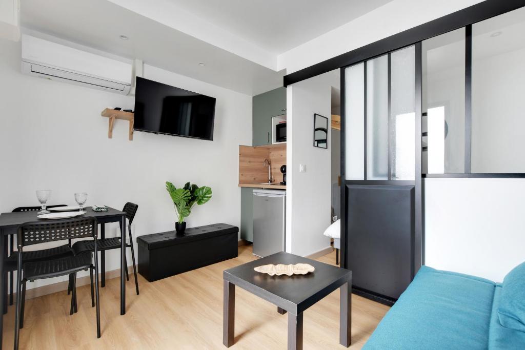 un salon avec un canapé bleu et une table dans l'établissement Charming 1 Bedroom with Sauna - Romainville 2, à Bagnolet