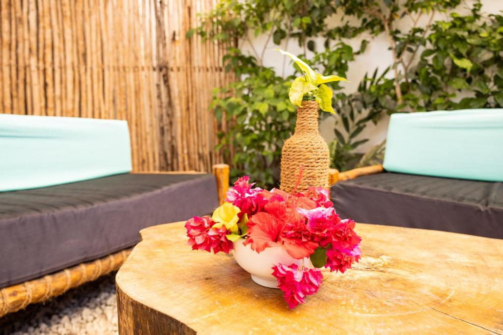 a vase filled with flowers sitting on a table at Hakuna Matata Boutique in Paje
