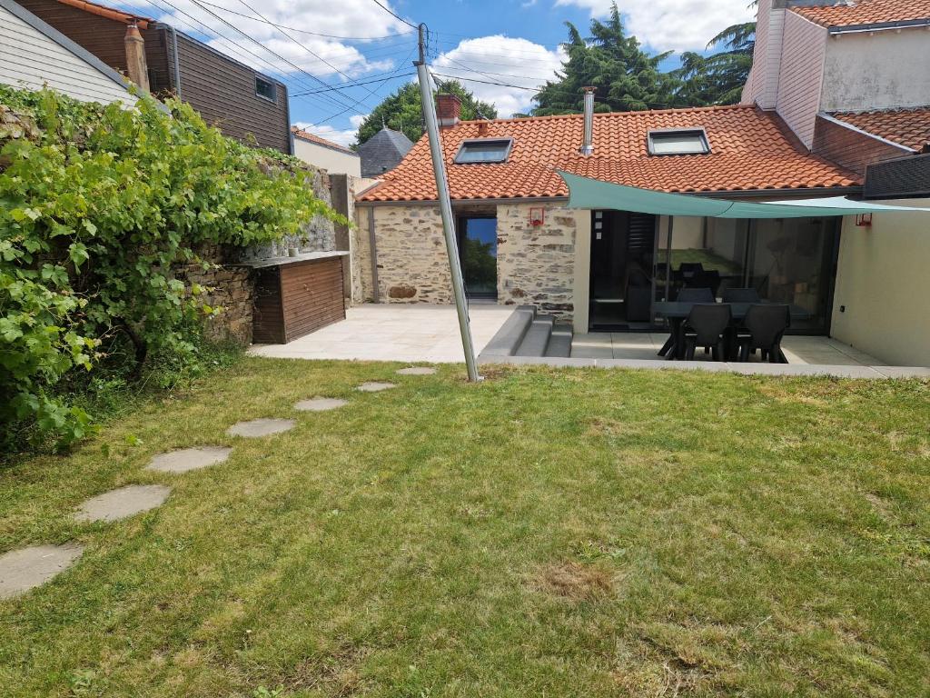 une arrière-cour avec une terrasse dotée d'une table et de chaises dans l'établissement Maison au calme et avec le charme de la pierre, gite 