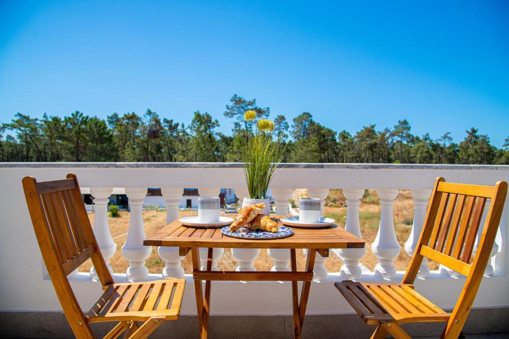 a table with a plate of food on a balcony at UFitness Retreat Guesthouse in Vila Real de Santo António