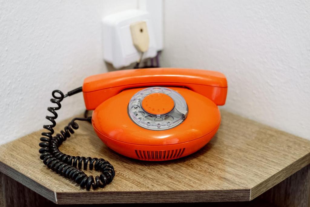 an orange phone is sitting on a wooden shelf at Retro Hotel JISKRA in Čeladná