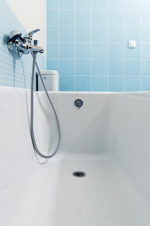 a bath tub with a shower in a bathroom at Retro Hotel JISKRA in Čeladná