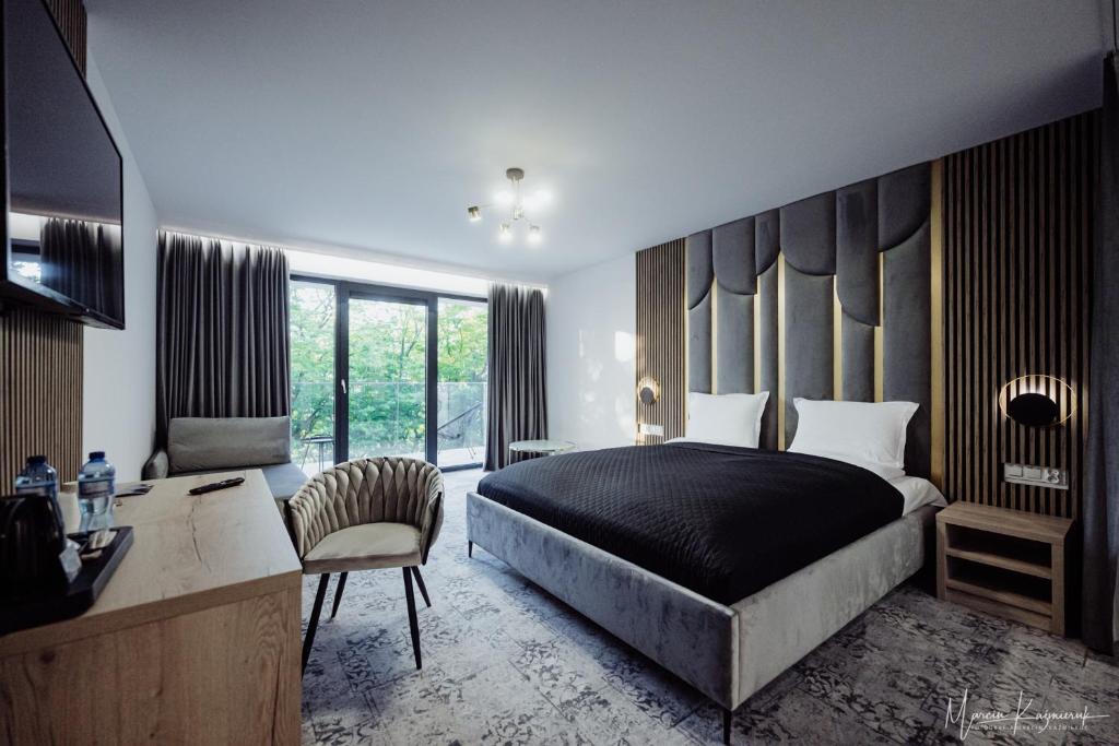 a bedroom with a king sized bed and a desk at Cristal in Ustka