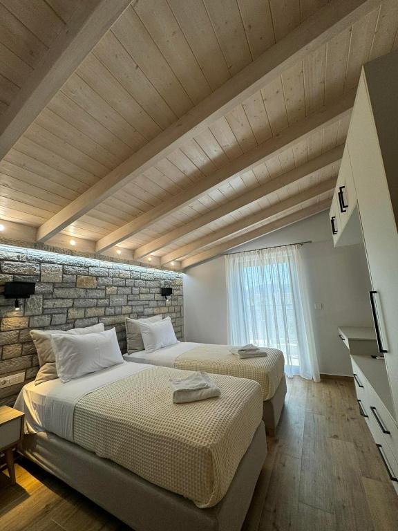 dwa łóżka w pokoju z ceglaną ścianą w obiekcie Iris Villas Complex w mieście Leukada (miasto)