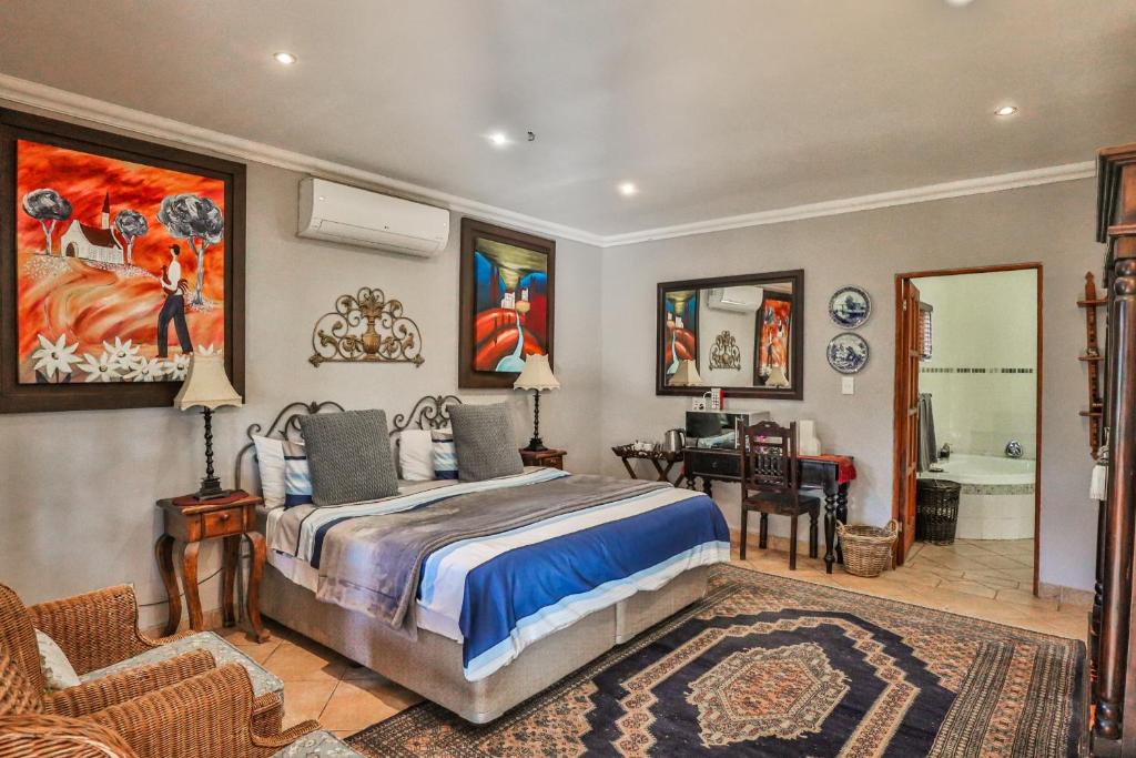 a bedroom with a bed and a desk in a room at Sunset Ridge Guest House in Rustenburg