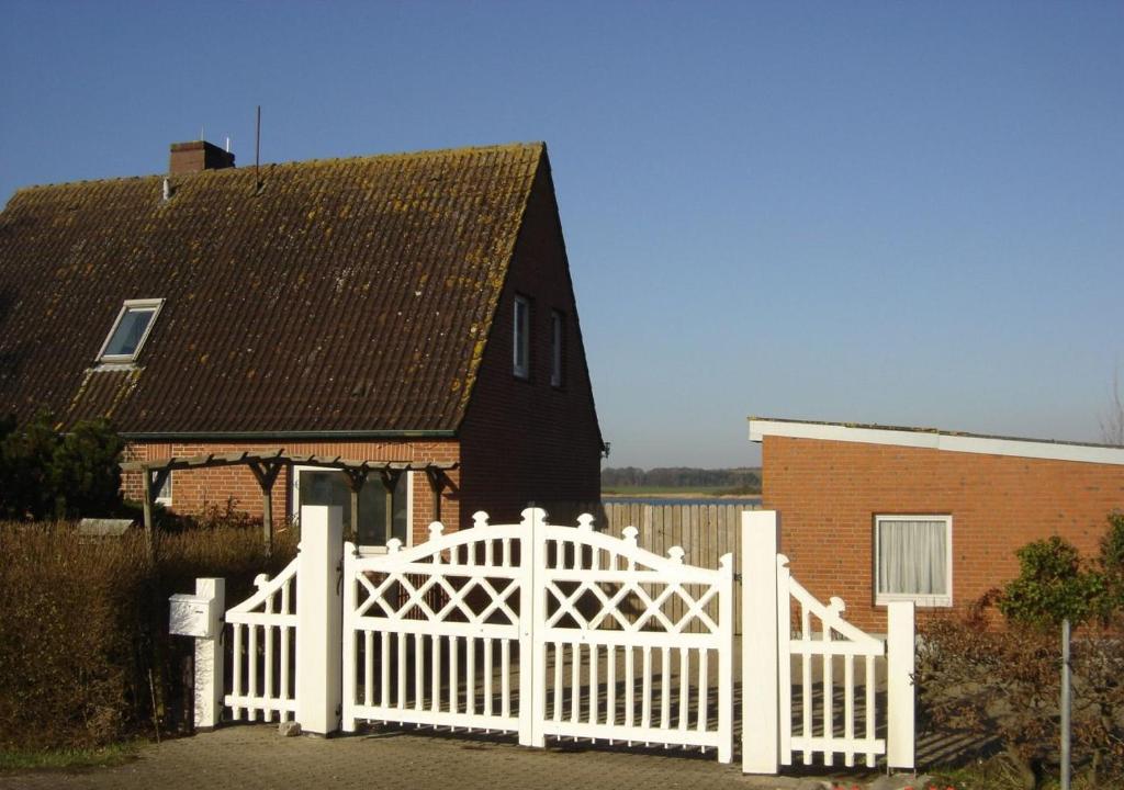 une clôture blanche devant une maison dans l'établissement Haus am Schlei Noor, à Maasholm