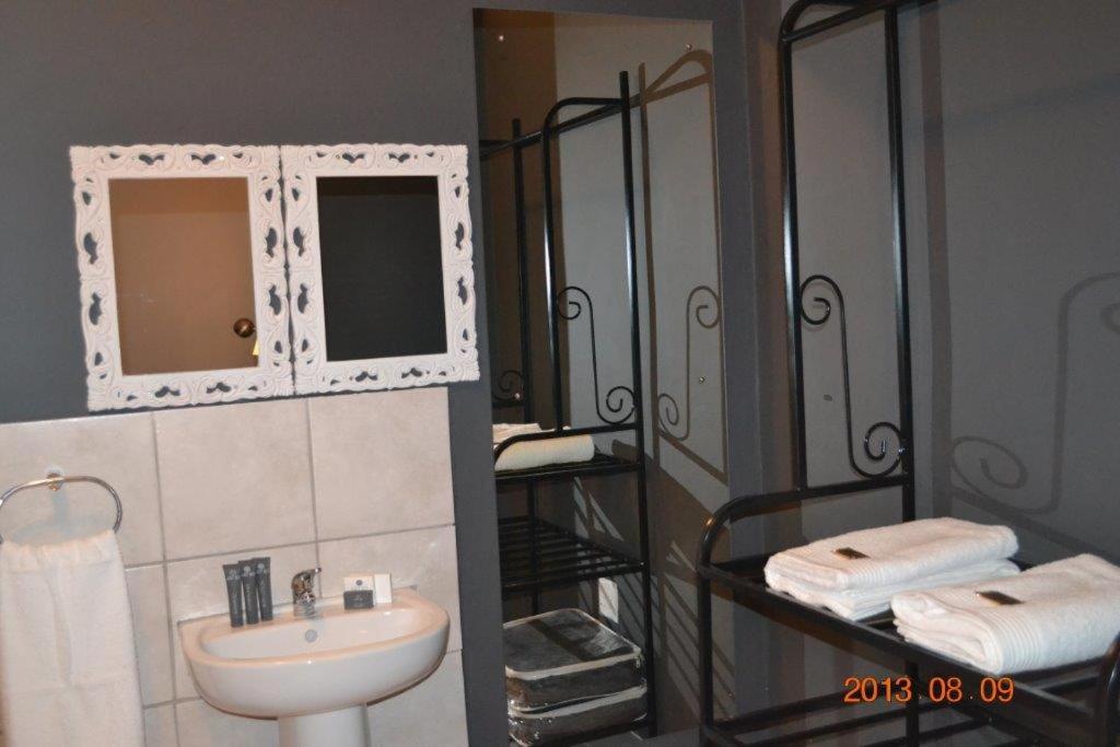 un bagno con lavandino e specchio di 7 Cities Guesthouse a Cradock