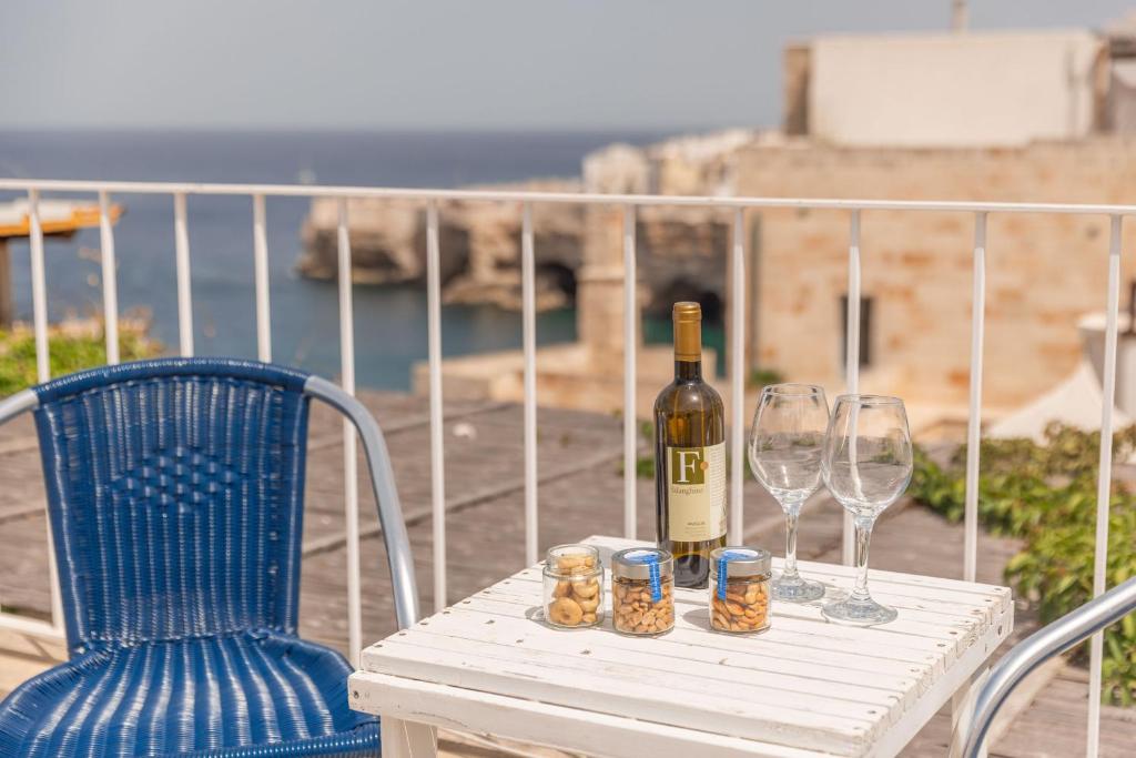 a table with a bottle of wine and two glasses at Elena's house 28 in Polignano a Mare