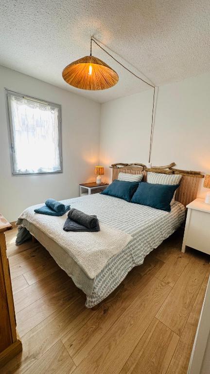 une chambre avec un grand lit avec des oreillers bleus dans l'établissement Appartement 2 à 4 personnes à 50m de la plage, à Lacanau-Océan
