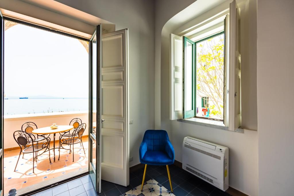 a room with a table and chairs and a balcony at Starhost - ANGOLO FELICE, charming seaview terrace in Vietri sul Mare