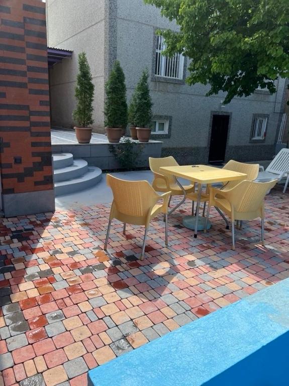 a patio with a table and chairs on a brick floor at Jrvezh House in Yerevan