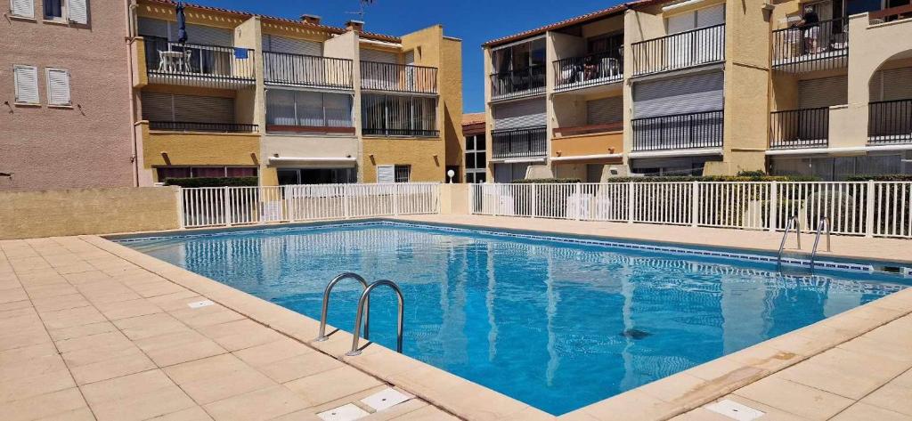 - une piscine en face de deux immeubles d'appartements dans l'établissement Appartement cap dagde, au Cap d'Agde