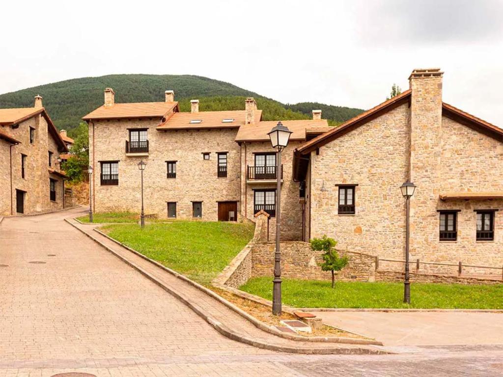 a large brick building with a road in front of it at Apartamentos Jaca Badaguas 3000 in Badaguás