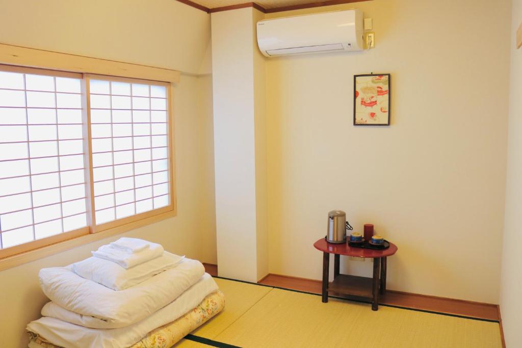 a room with a pile of towels on the floor at Ikoi-no-Ie Guesthouse in Kyoto