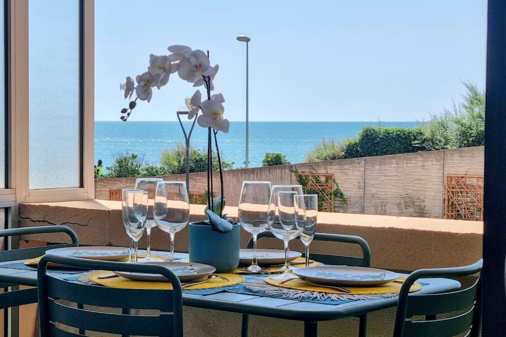 uma mesa com copos de vinho e vista para o oceano em LE MARTY 7 Vue Mer Centre Terrasse Garage Piscine Climatisation em Sète