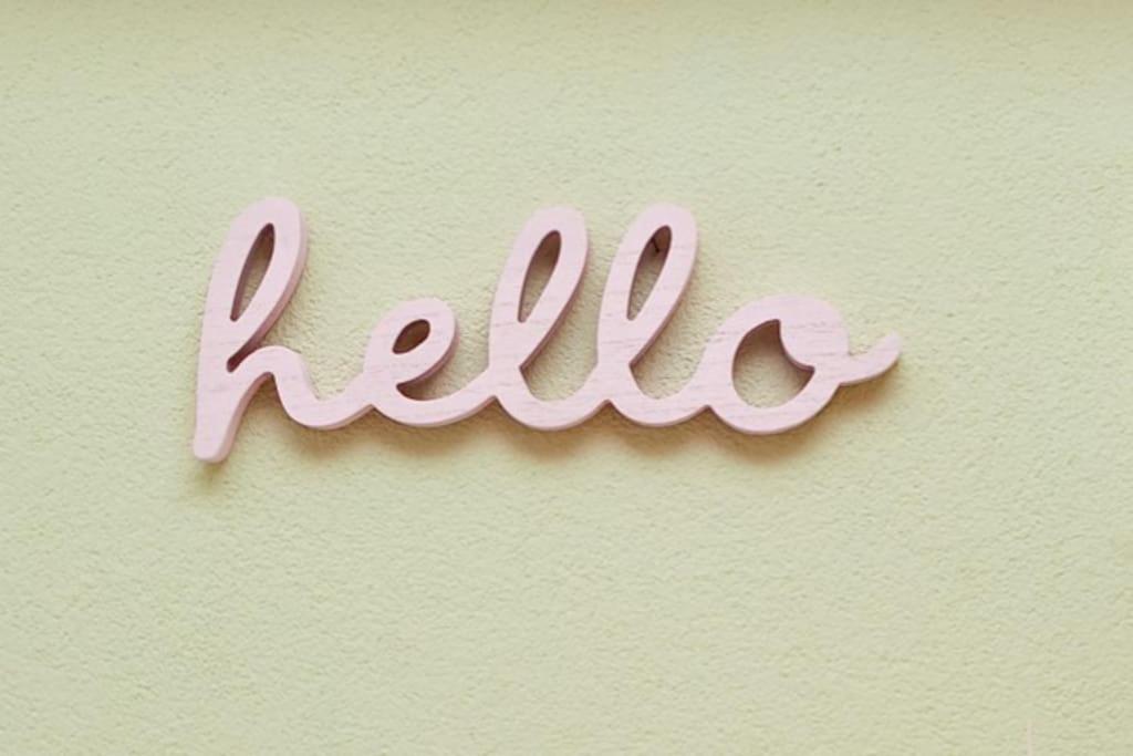 a hello written in pink writing on a wall at La mansardina in Trieste