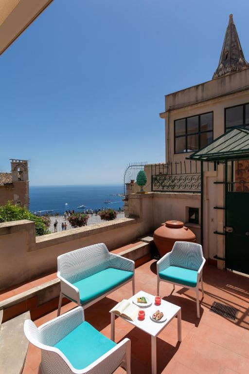 a patio with chairs and a table and the ocean at Casa Acropoli Sea View Taormina Center in Taormina