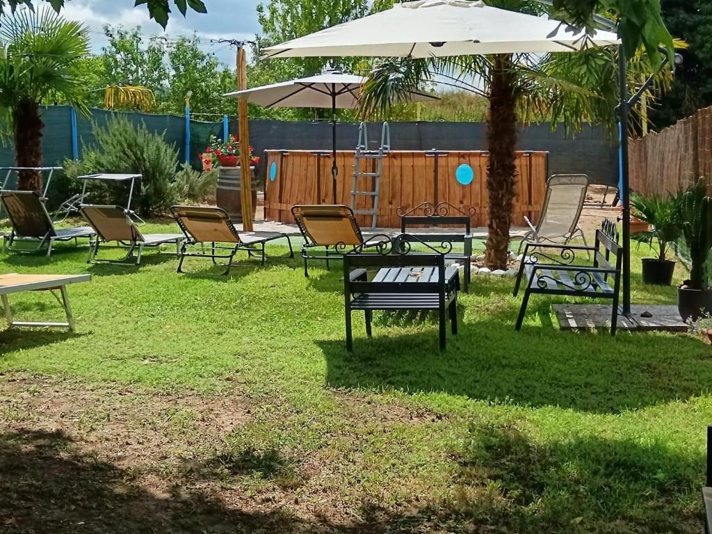 a group of chairs and an umbrella in a yard at La casa di Mary in Castiglion Fiorentino