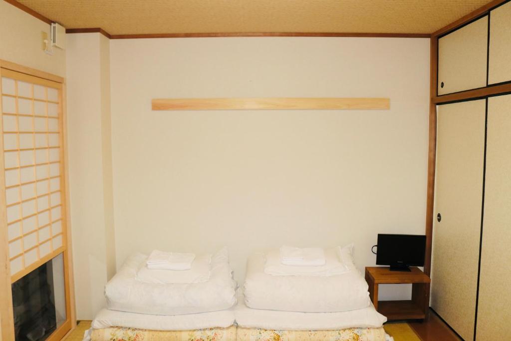 una stanza con due cuscini bianchi su una parete di Ikoi-no-Ie Guesthouse a Kyoto