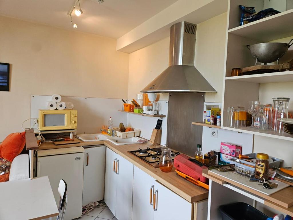 une cuisine avec des armoires blanches et un four à plaques de cuisson dans l'établissement Un calme près de l'eau, à Lanvéoc