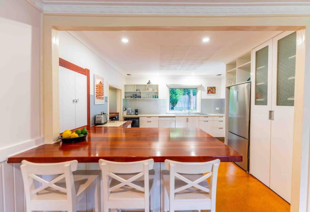 a kitchen with a large wooden table and white chairs at Havehus in Denmark
