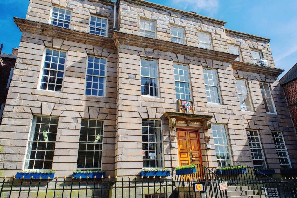 a large stone building with a orange door at St John's College in Durham
