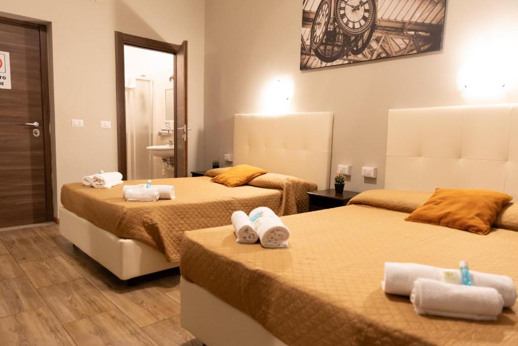 a hotel room with two beds with towels on them at Golden Milano Hotel in Milan