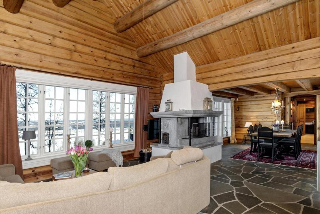 a living room with a couch and a fireplace at Cozy family cabin with stunning location on Golsfjellet in Golsfjellet