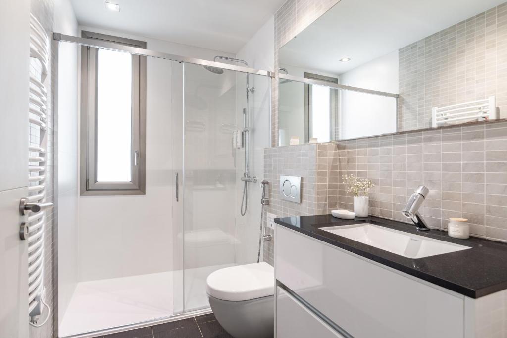 a bathroom with a toilet and a sink and a shower at Aspasios Paseo de Gracia Apartments in Barcelona