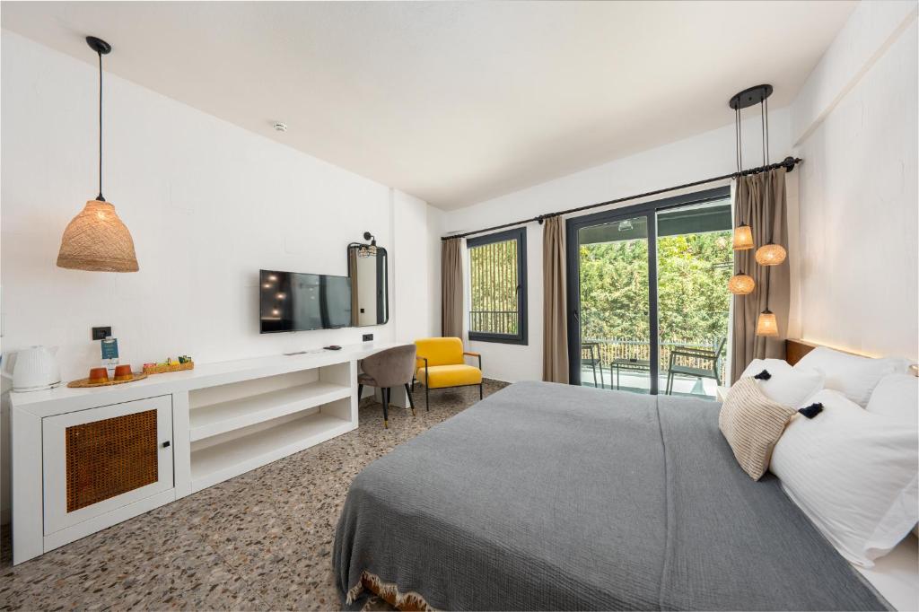 a bedroom with a bed and a desk and a tv at Ölüdeniz Blu Luxury Unique Hotel - Adults-Only in Oludeniz