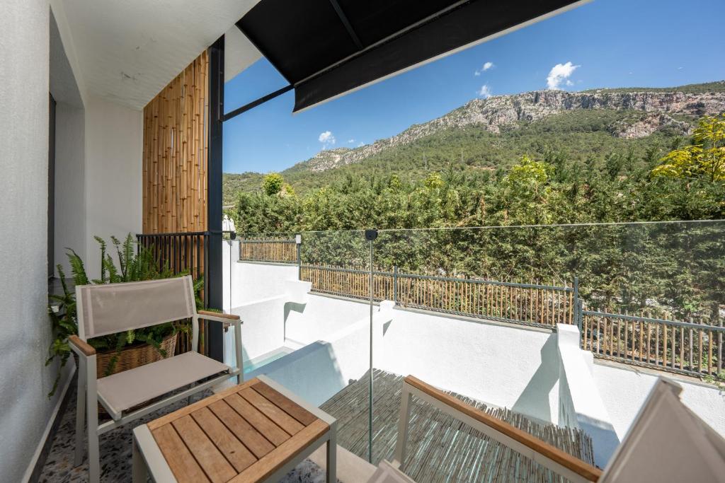 a balcony with a chair and a view of the mountains at Ölüdeniz Blu Luxury Unique Hotel - Adults-Only in Oludeniz
