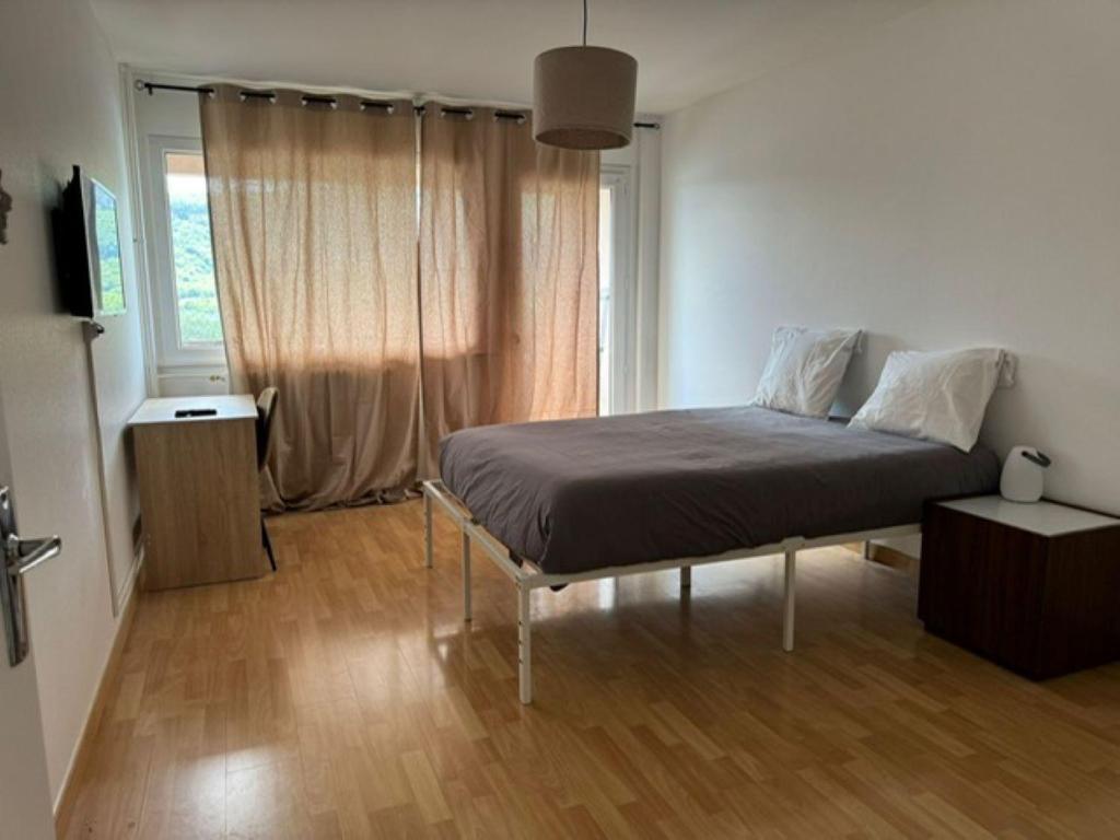 une chambre avec un lit dans une pièce avec une fenêtre dans l'établissement M63 Marquer T2 au calme Ville La Grand, à Ville-la-Grand