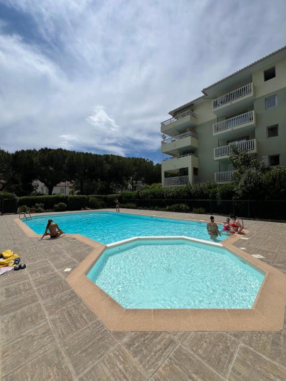 une grande piscine avec des personnes assises autour de celle-ci dans l'établissement 2Pièces, Piscine, Terrasse, à Cagnes-sur-Mer
