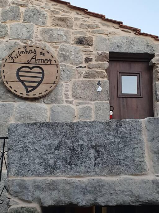 a sign on the side of a stone building with a door at Fuinhas de Amor in Fornos de Algodres