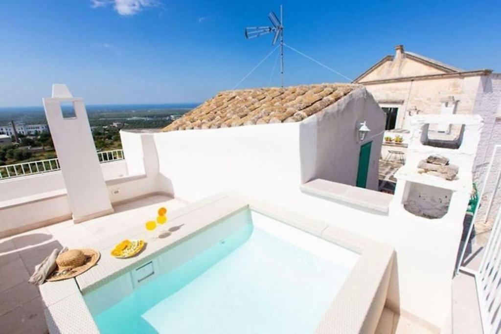 a white house with a swimming pool on a roof at Italianway - Casa Leo in Ostuni