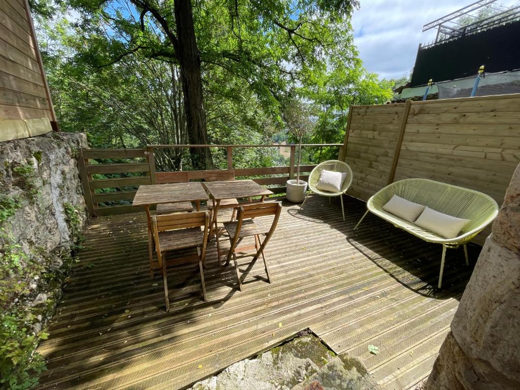 a wooden deck with a table and chairs on it at Chez Gabriel et Sophie in Pérouges