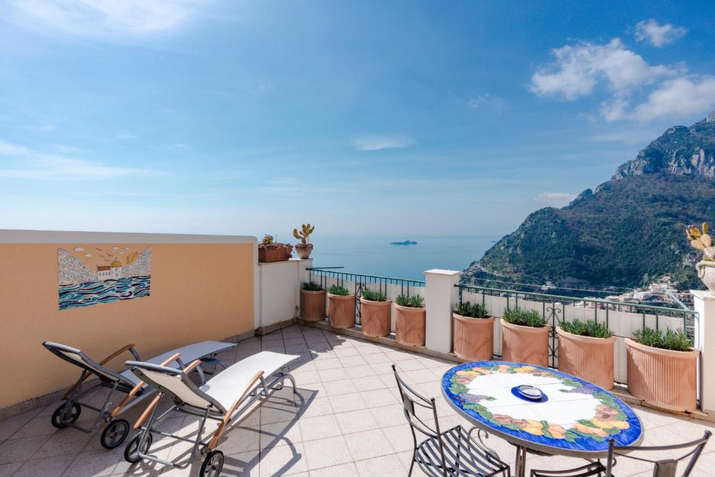 uma varanda com mesa e cadeiras e o oceano em Casa Monticello em Positano