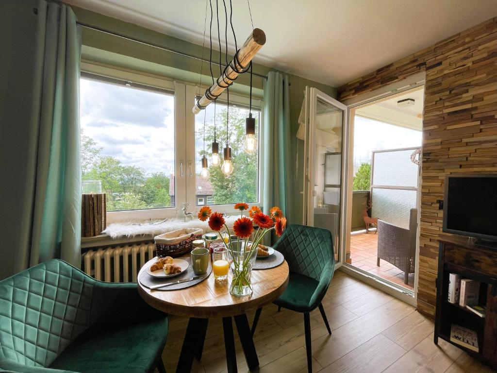 a living room with a table and chairs and a window at LIGHTQUARTIER Mountain Nest -Balkon in Sankt Andreasberg