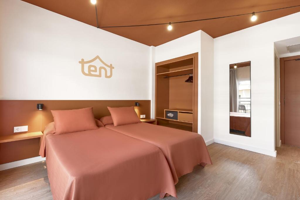 a bedroom with a bed with pink pillows at tent Bahia de Palma in El Arenal