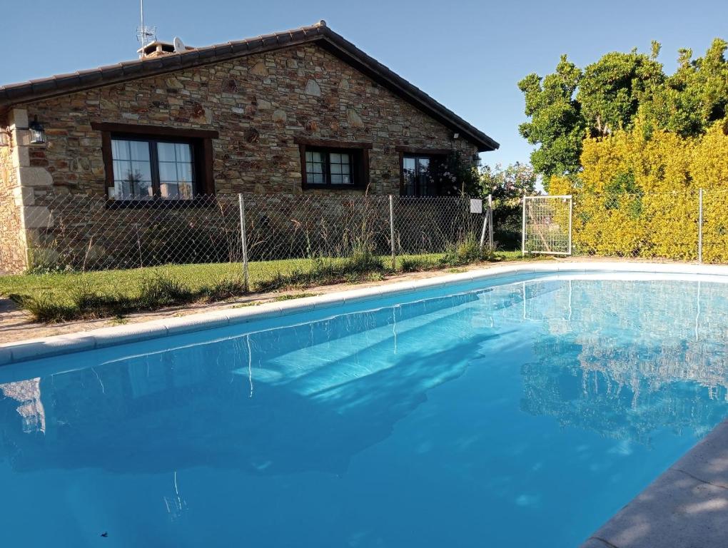 a swimming pool in front of a house at Ruta Del Aguila alojamiento turístico de calidad in Santa María de la Alameda