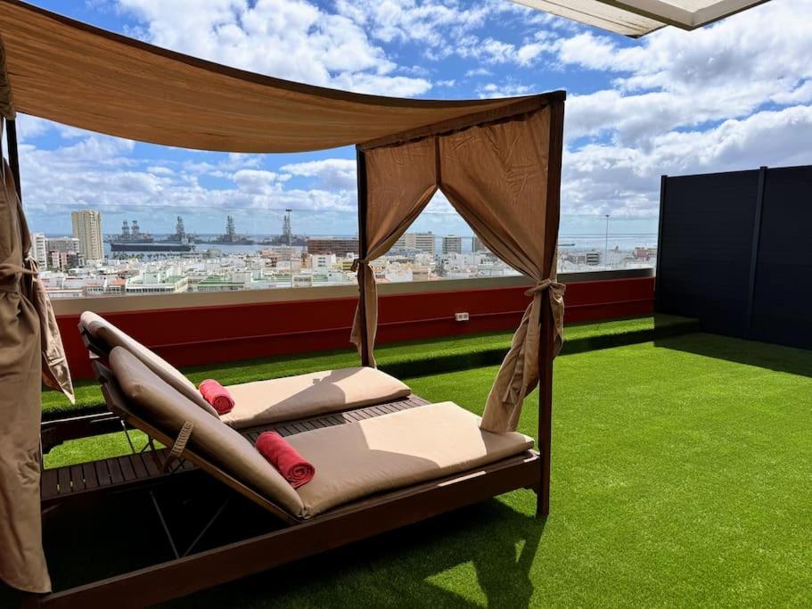 a bed on a balcony with a view of a city at Panoramic Design Loft in Las Palmas de Gran Canaria